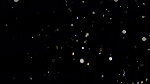 Schwebende weiße Staubpartikel im Lichtstrahl auf schwarzem Hintergrund