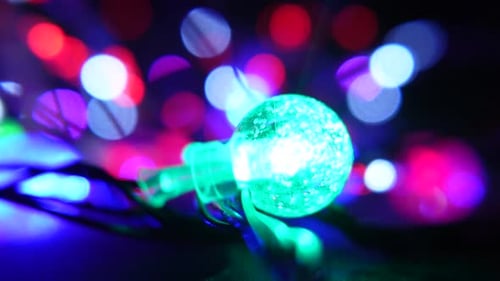 Vibrant multicolor string lights with glowing red and green bulb accents against a soft bokeh