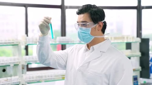 Medical biochemist using microscope while working on scientific research in laboratory.