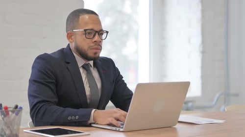 Professional Man Working on Laptop in Bright Office