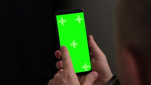 Closeup Man Hand is Holding Chroma Key Green Screen in Vertical Position