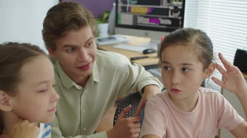 Children Learning with Young Man at Computer