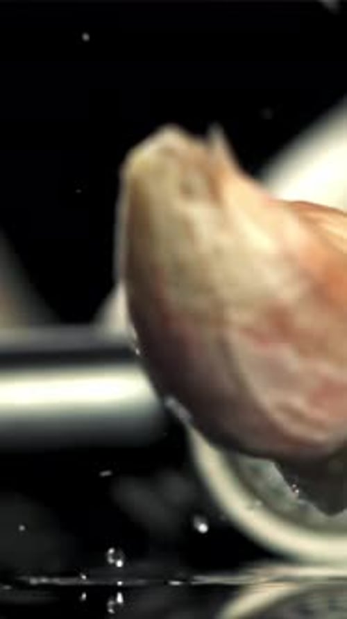 Garlic Falls on a Black Table with Splashes Filmed on a Highspeed Camera at 1000 Fps
