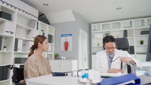 Asian cardiologist doctor listen to heartbeat patient woman in hospital.