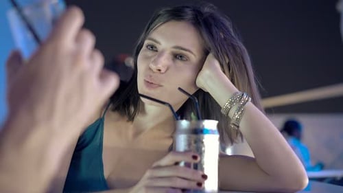 Young, Happy Couple Drinking Beverages and Talking in Bar at Night Adult