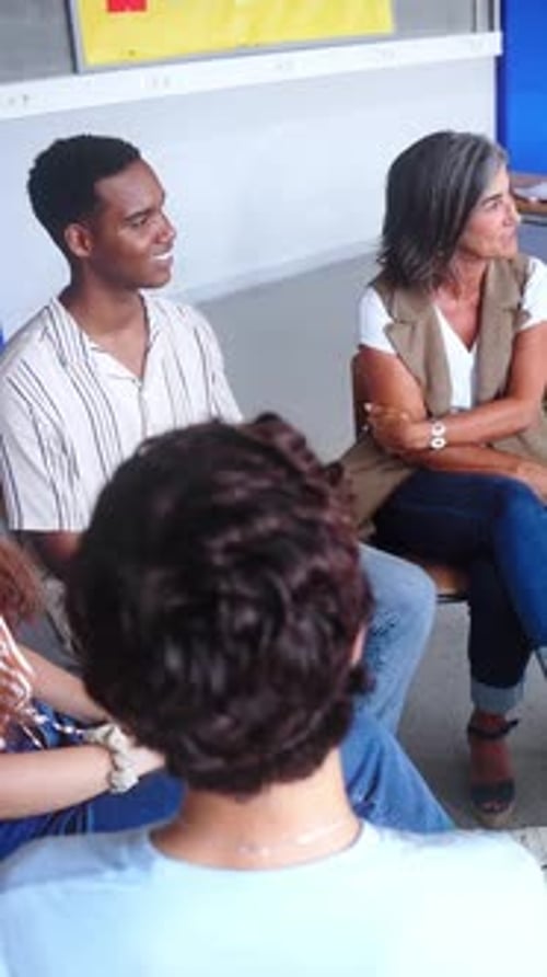 Diverse Happy Group of High School Students Sitting on Chairs in Circle Interacting During Lesson