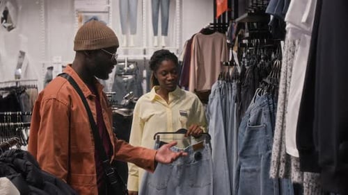 Shop Assistant Helping Man in Clothes Store