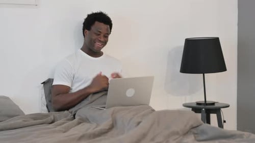 Smiling Man Video Calling From Bed on Laptop