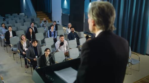 Back View of Male Press Officer Giving Interview for Media in the Conference Hall