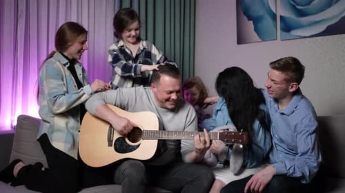 Family Gathers to Listen to Guitar Music at Home