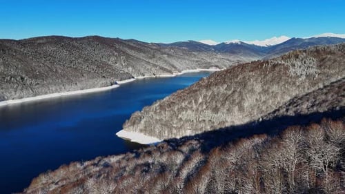 Winter landscape with mountain lake in winter season. Mountain forest lake