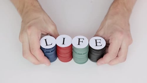 Mãos masculinas apostando tudo com fichas de pôquer com a palavra LIFE. Vício em jogos de azar.