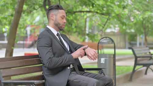 Man in Suit Waiting on Bench in Park