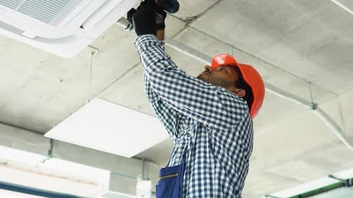 Indian Technician Installs Air Conditioning System at Office