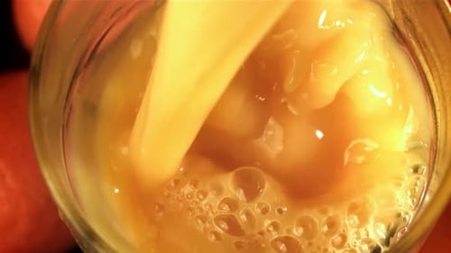 Golden Liquid Pouring into Glass