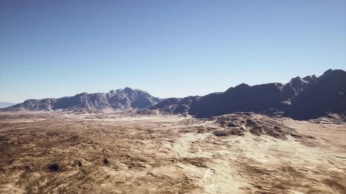 Desert Landscape Scene Sunlit Cracked Earth and Lonely Ridge Line