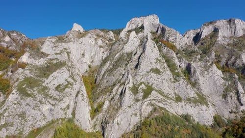 Flug über Kalksteinfelsen und Herbstwald aus der Vogelperspektive