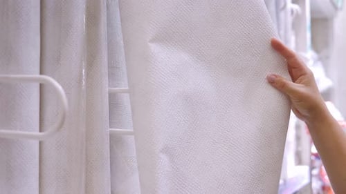Closeup of a Woman Choosing Wallpaper in a Hardware Store