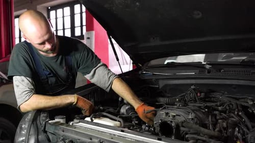 Auto Mechanic is Diagnosing an SUV Engine Auto Repair Station