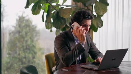 a serious man a businessman works at a laptop in the office communicates with colleagues