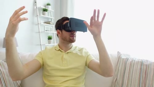 Young Man Experiencing Virtual Reality Headset on Sofa