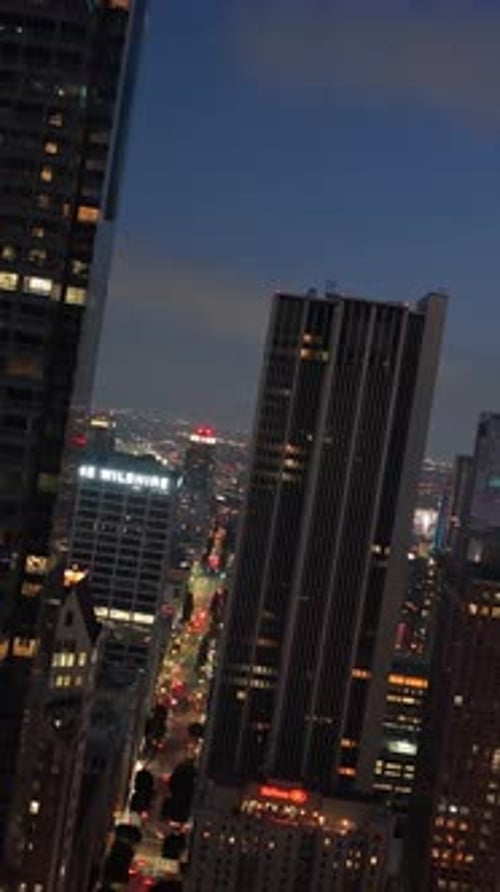 Dutch Tilt Aerial Moving Between Urban Skyscrapers in Downtown Los Angeles at Night Showing Glowing