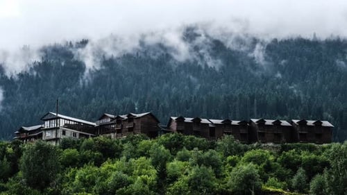 Morning Fog Over Wooden Cottages in the Mountains