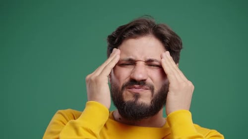 Bearded Man Massaging Temples in Pain