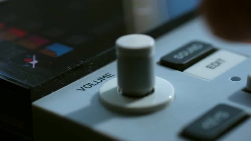 Mann passt die Lautstärketaste auf dem Bedienfeld in der Studio-Nahaufnahme an