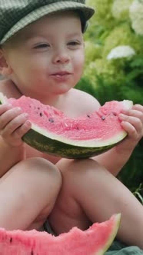 Child Enjoys Watermelon Snack in Garden Setting