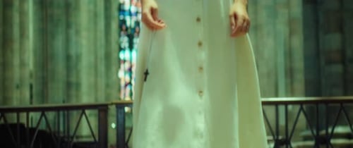 Une
pieuse dame âgée priant dans la vieille église. Paroissien tenant une croix religieuse à la main
et marchant