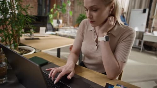 Female Office Employee Using Laptop and Collaborating with Colleague