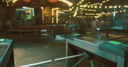 Entrada a un animado parque de atracciones con luces brillantes y atracciones