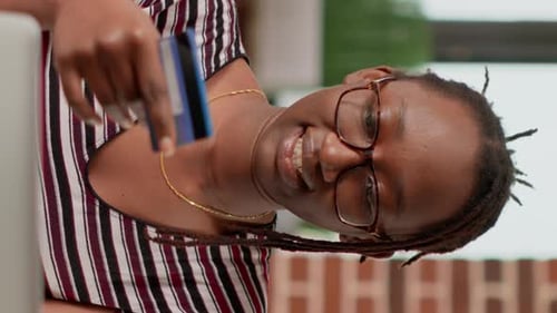 Woman Holds Credit Card and Looks at Computer