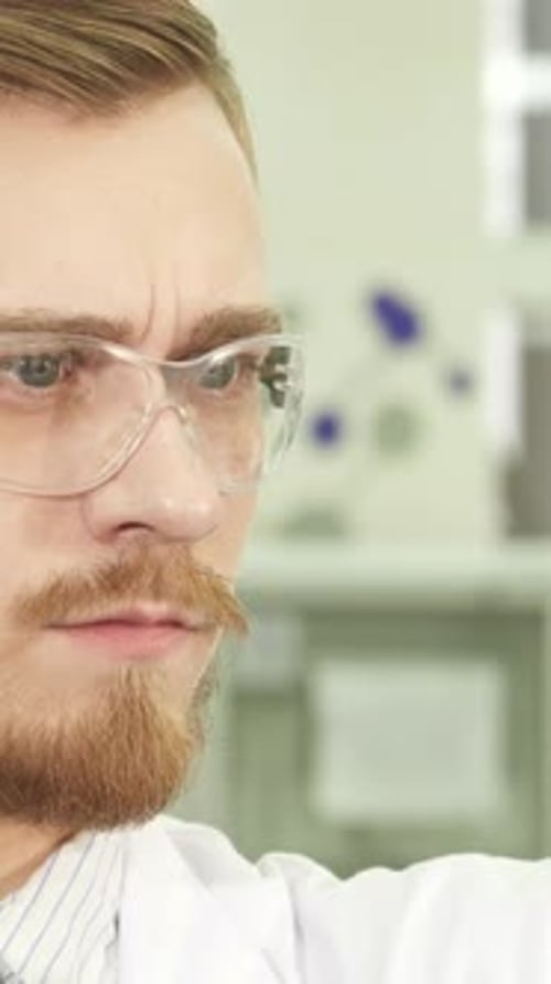Close Up of Scientist Looking Through Safety Glasses
