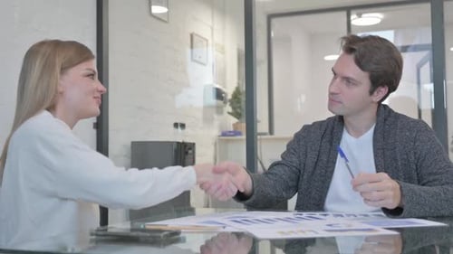 Young People Shaking Hand after a Deal in Office