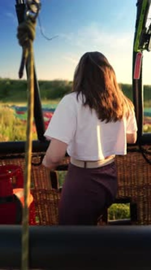 Woman is Standing in the Basket of Hot Air Balloon on the Field After the Flight and Going Out of It
