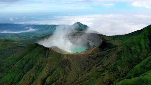 Luftaufnahme des majestätischen Ijen-Vulkankraters mit grünen Bergen in Ost-Java