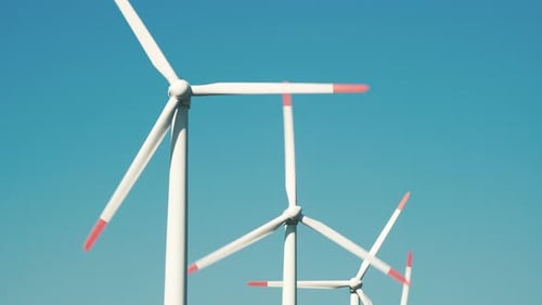 Large rotating wind turbine blades against the blue sky