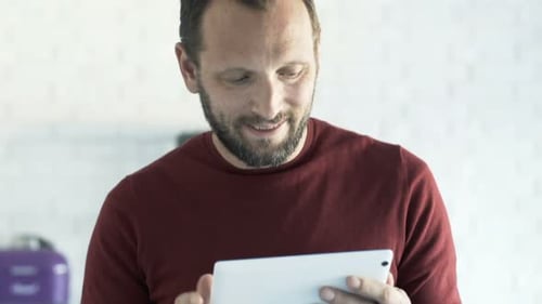 Man using tablet device in bright indoor setting