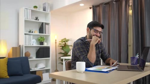 Man Analyzes Data in Home Office, Happy