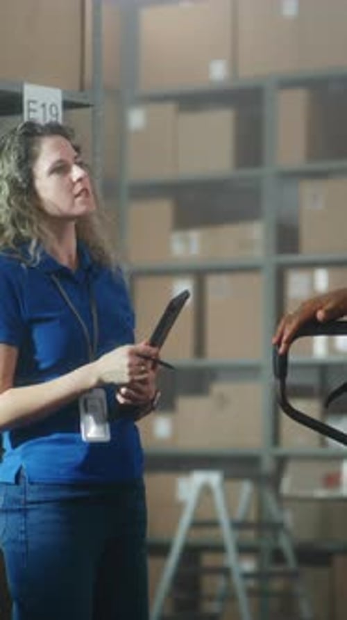 Female Logistics Manager with Tablet Computer Talks to Colleagues Gives Instructions for Delivery