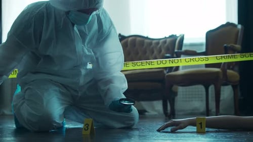 Investigator Examines Arm with Magnifying Glass at Crime Scene