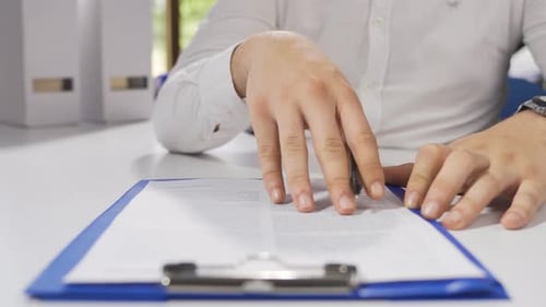 Der Geschäftsmann prüft die Vertragsunterlagen und unterschreibt sie.