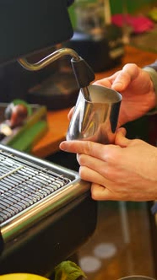 Barista Crafts Latte Art in Cozy Cafe Setting