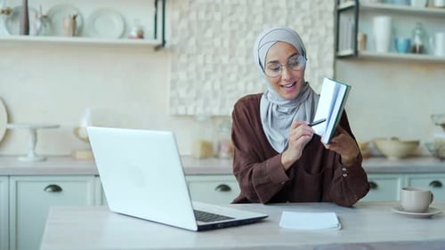 Young Woman in Hijab Attends Virtual Meeting at Home