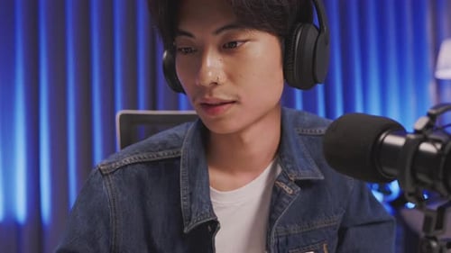 Close up of focused content creator livestreaming with microphone and headphones