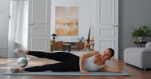 Woman Does Leg Lifts During Pilates at Home