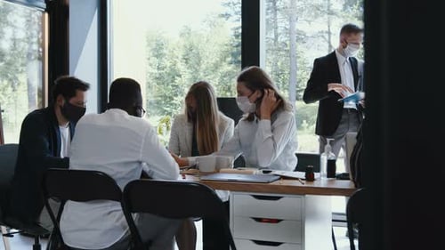 Team of Diverse Young Happy Business People Working at Modern Office Table Wearing Masks