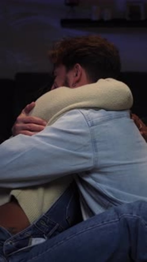 Couple Hugging Affectionately on Sofa at Home